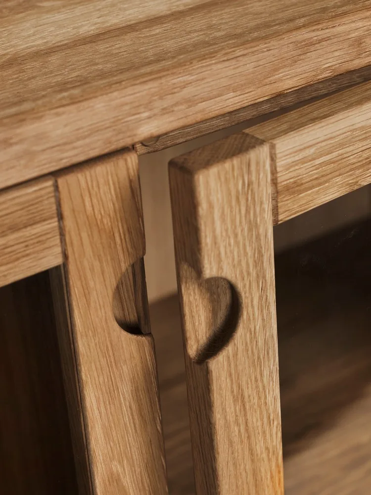 Two light wood panels, each with a heart-shaped cutout, on a piece of furniture.
