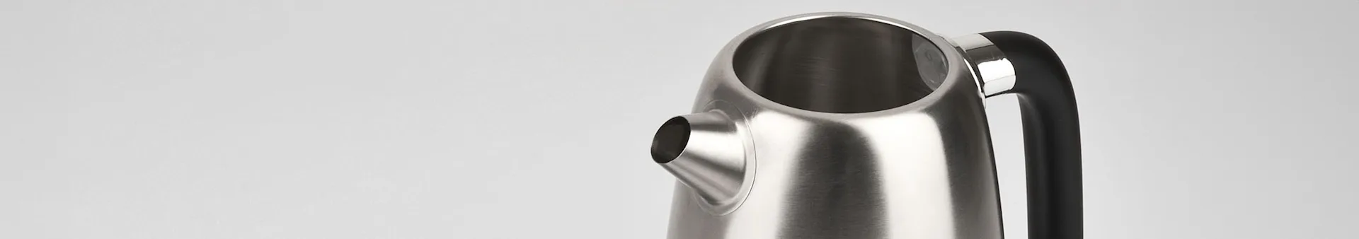 Upper view of a brushed stainless steel kettle with black handle and a spout.