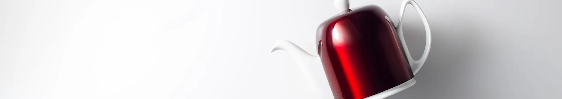 A shiny red and white coffee pot, tilted on a white background.