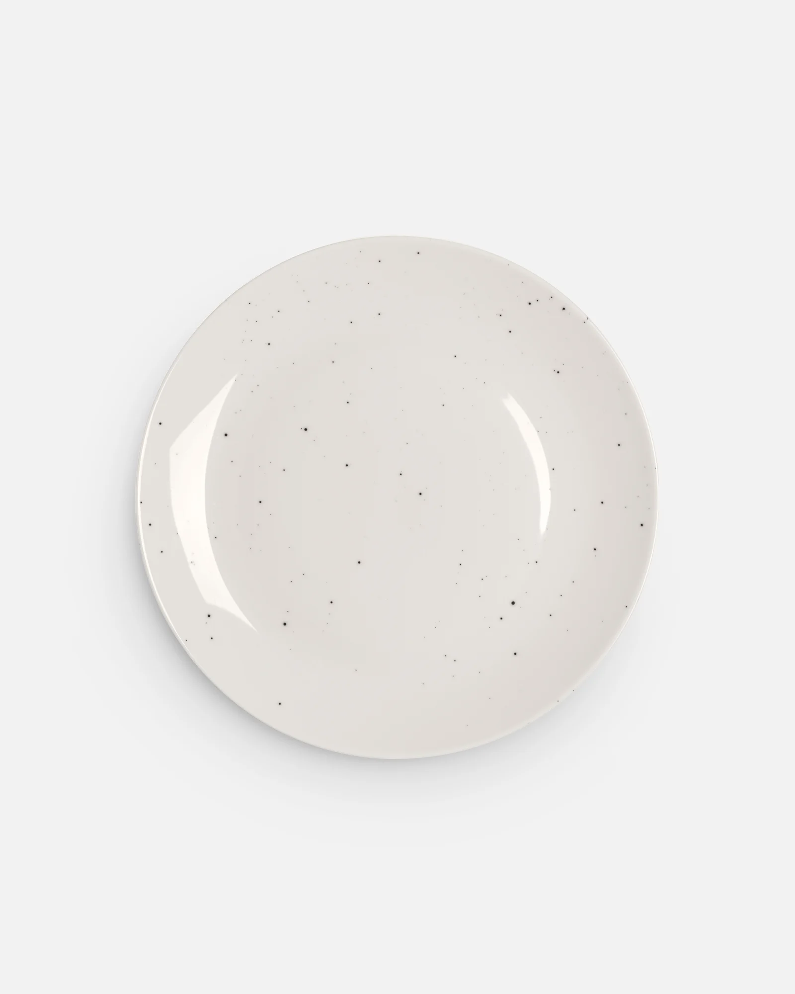 A single, round, off-white speckled plate with a subtle rim on a white background.