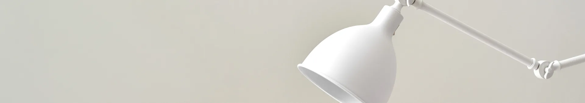 White, modern desk lamp with adjustable arm and conical shade, against a light gray background.