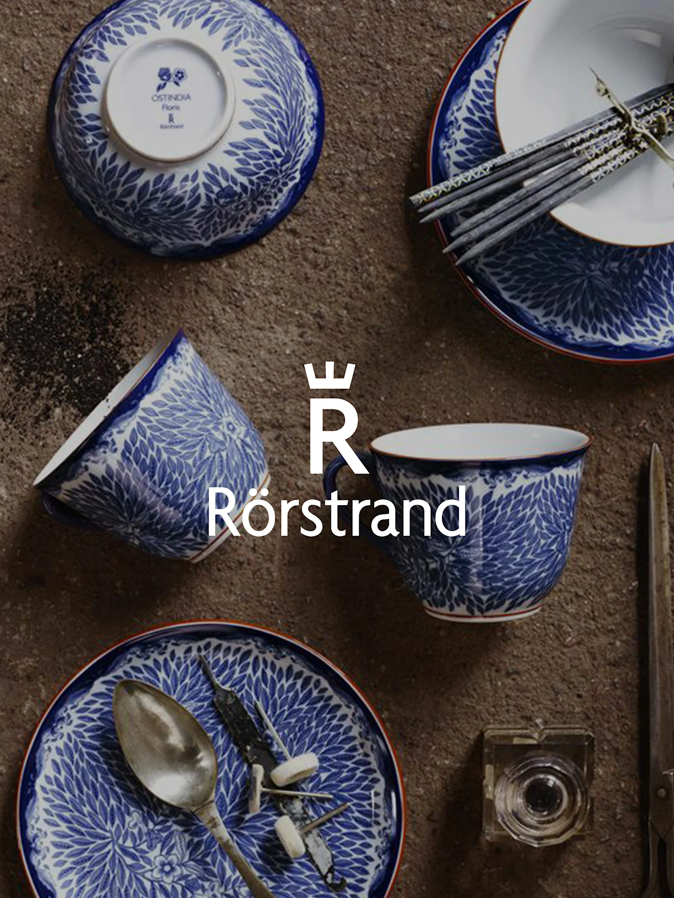 Blue and white patterned ceramic tableware including bowls, cups, and plates, with chopsticks, a spoon, and the Rörstrand logo.