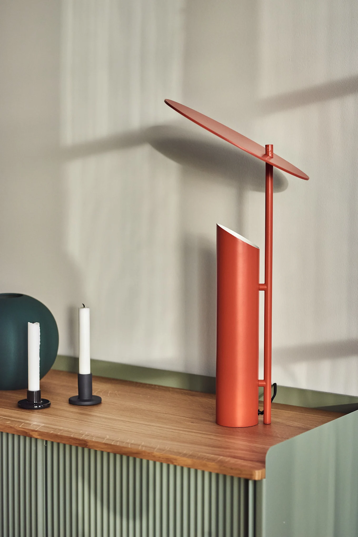On a sideboard stands the Reflect table lamp in red by Verpan, designed by Verner Panton.