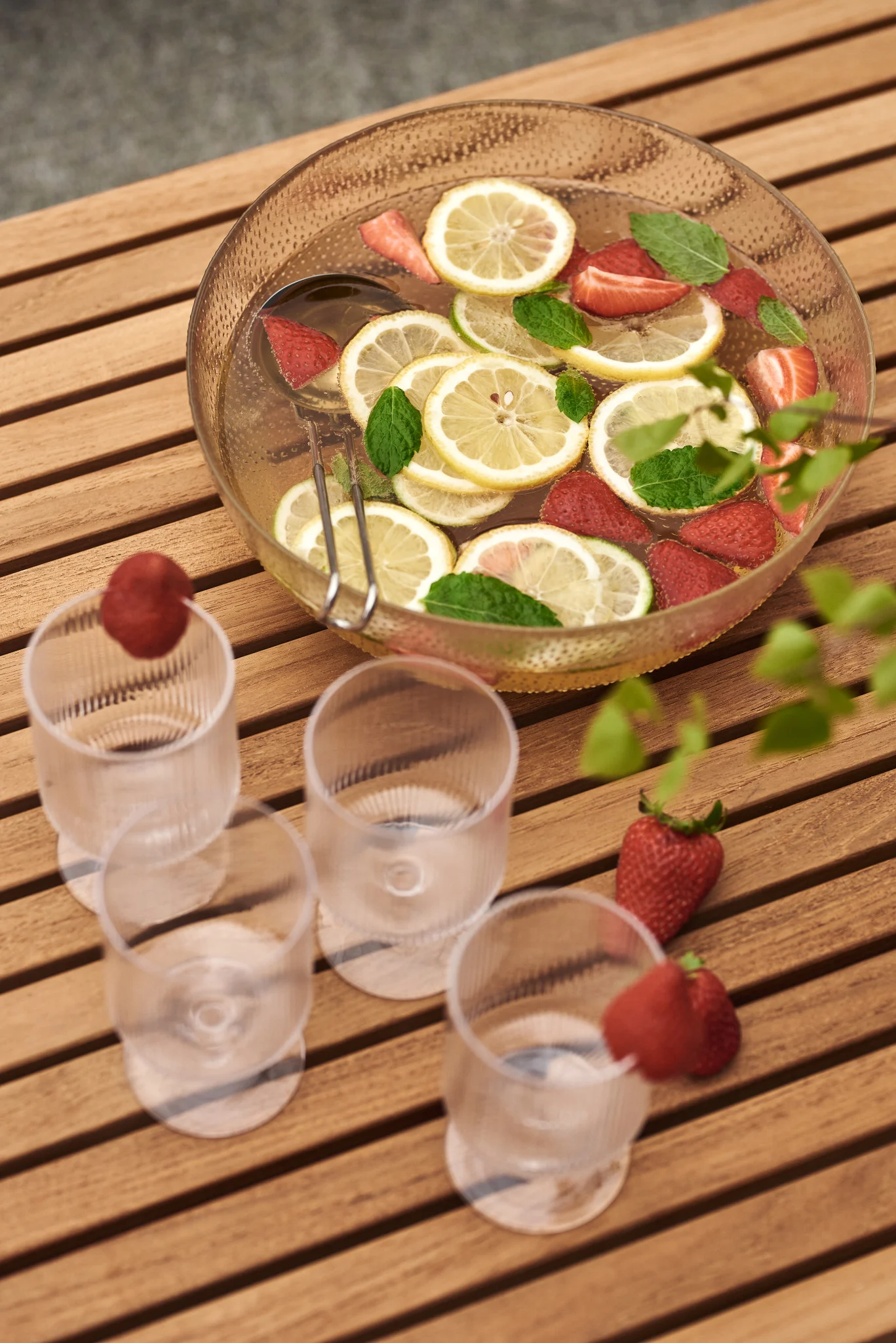 Enjoy a simple summer cocktail recipe this year: Here you see a glass bowl filled with lemons and strawberries.