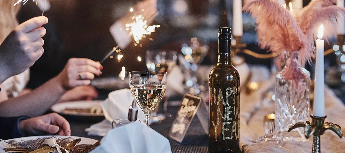 New Year party ideas - group says cheers to the new year with raised glasses.