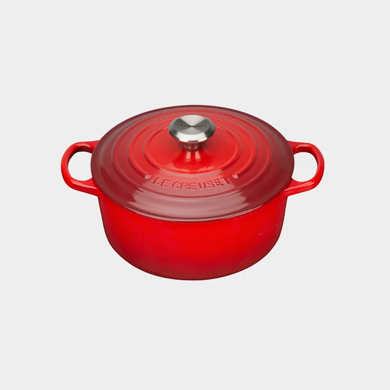 Red Le Creuset round dutch oven with lid and silver knob.