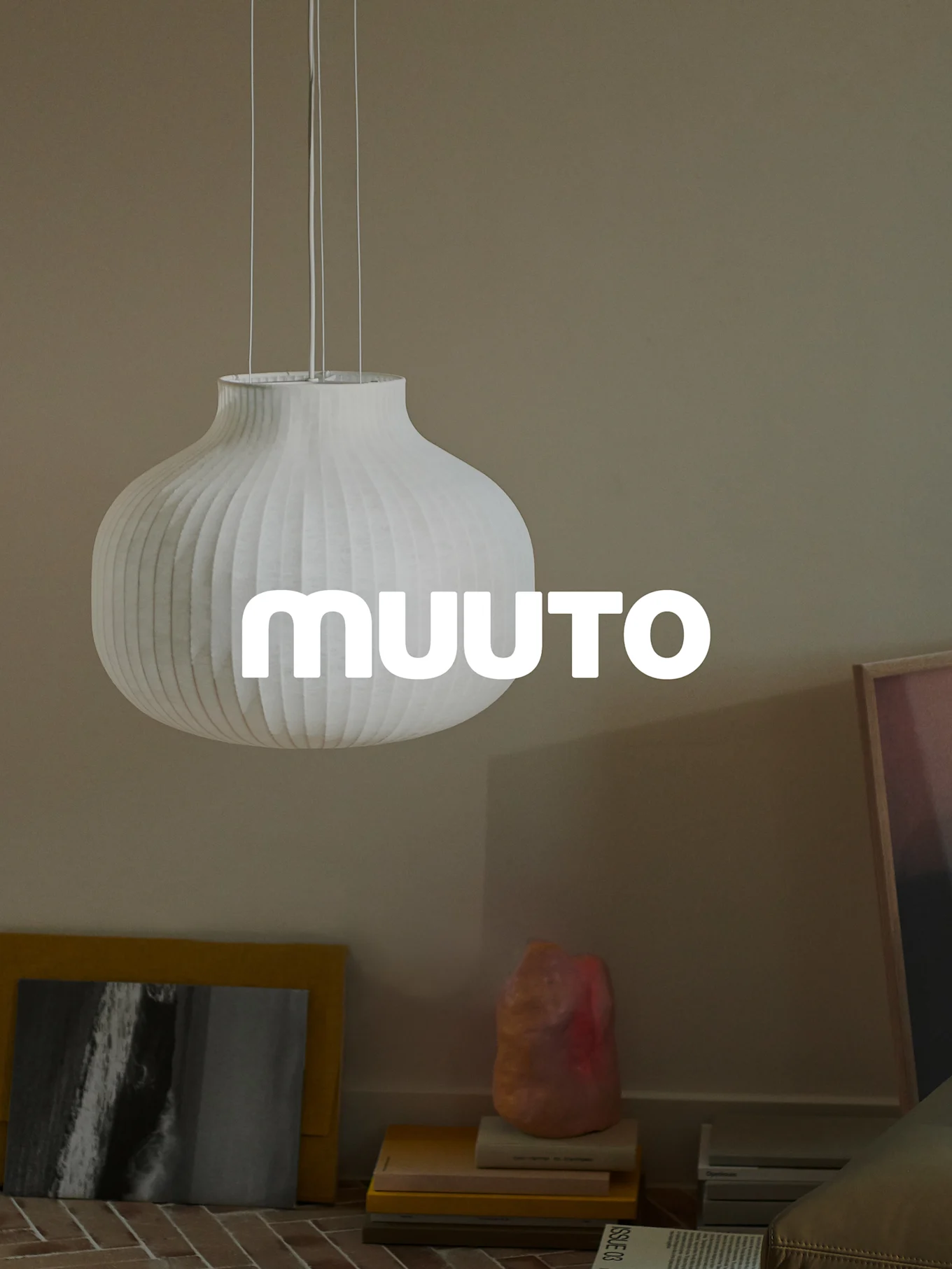White ribbed gourd-shaped pendant lamp with 'MUUUTO' logo, in a beige room.