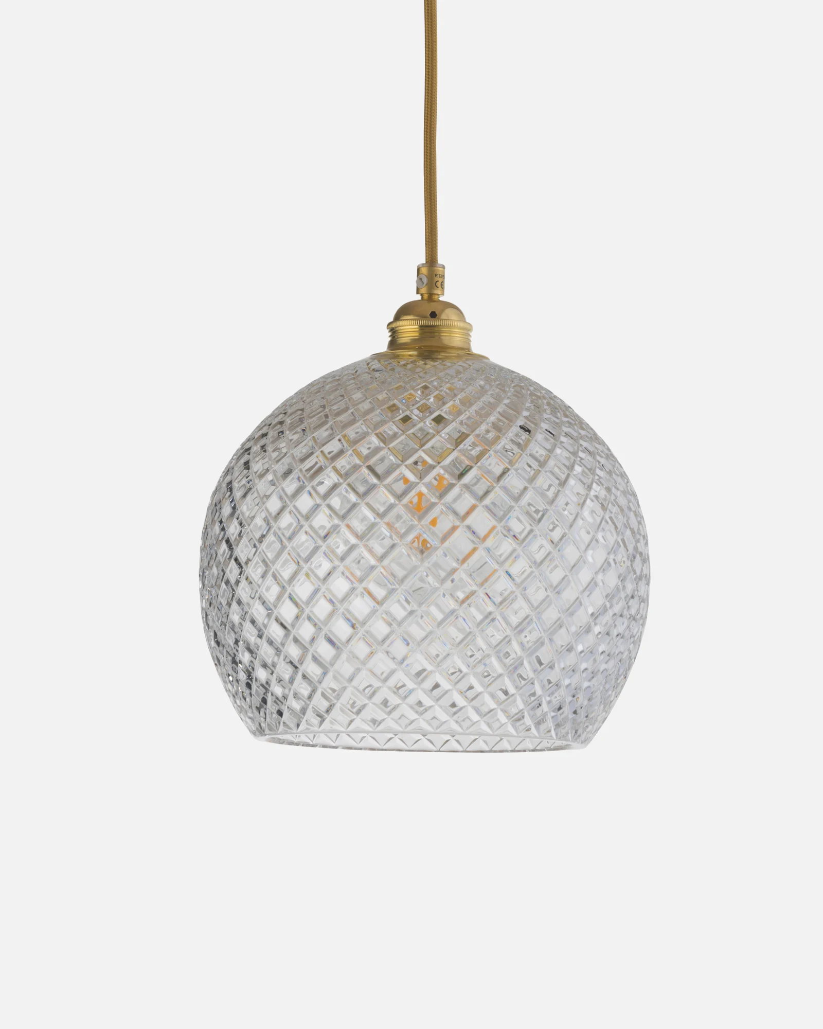 A spherical glass pendant light with a diamond-cut pattern, suspended by a brass fitting and gold braided cord.