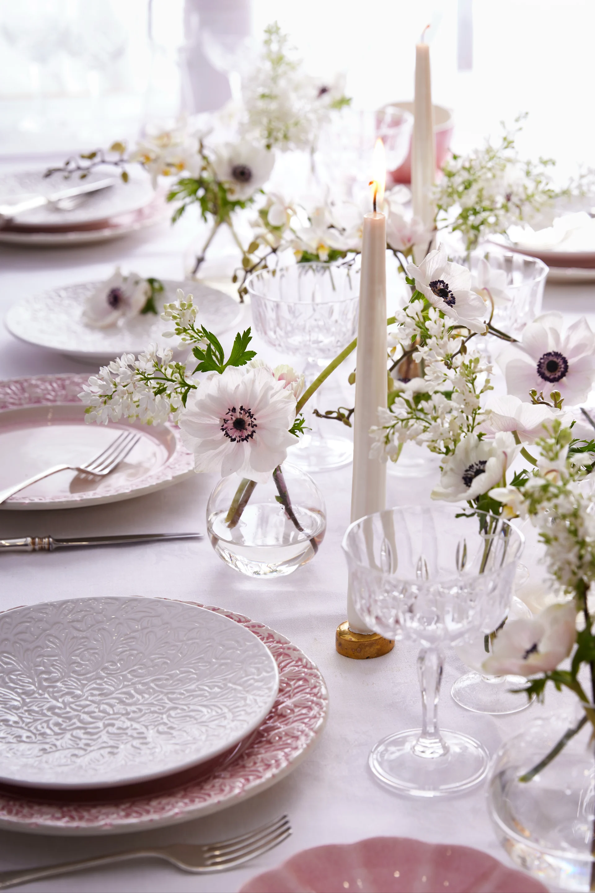 Table decorations in white and pink, plates from the Lace collection by Mateus, stylish glasses, candles and flowers.