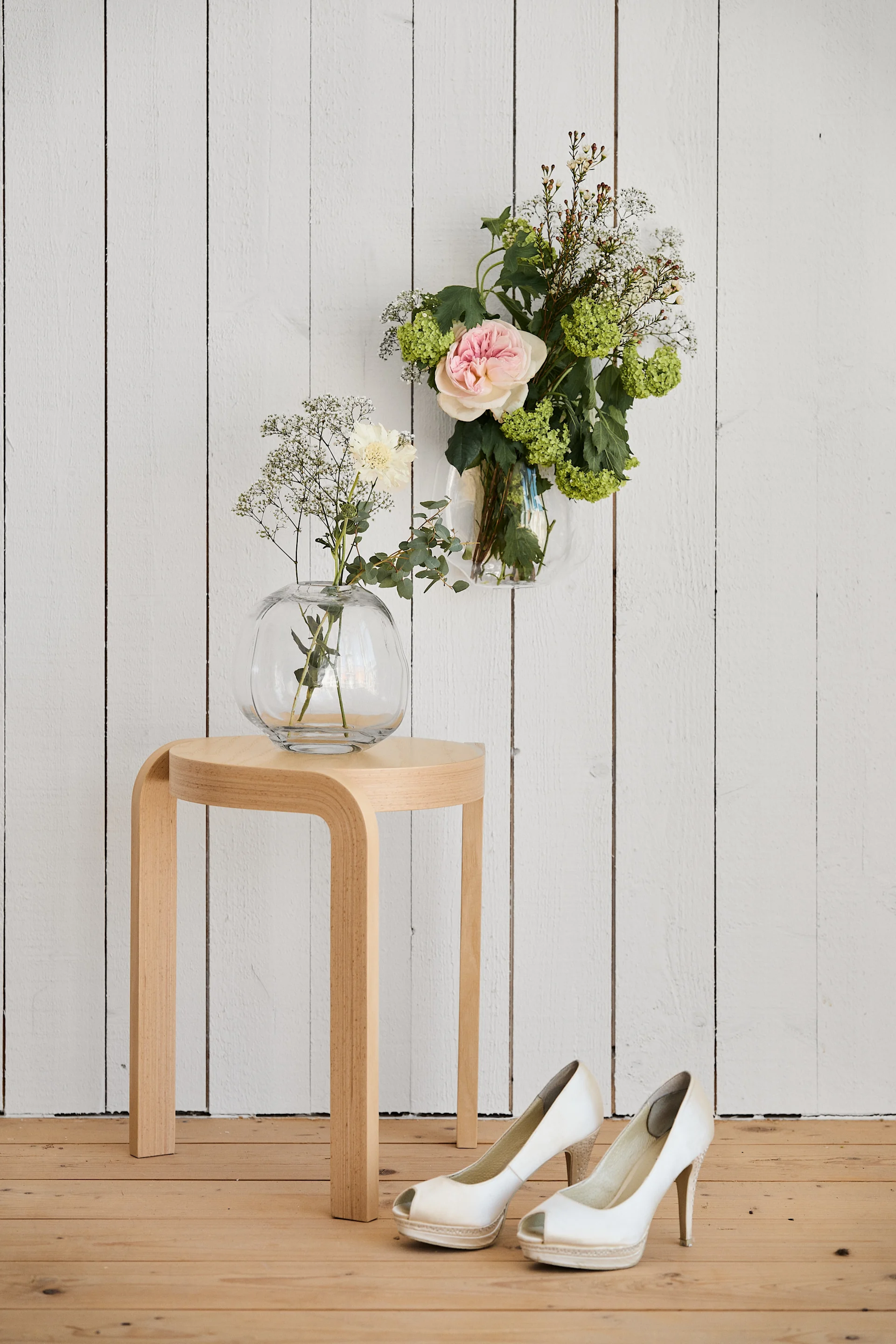 Unique wedding ideas need to be photographed to be remembered. Here you see the Swedese wooden stool and two vases hanging over a pair of wedding shoes.