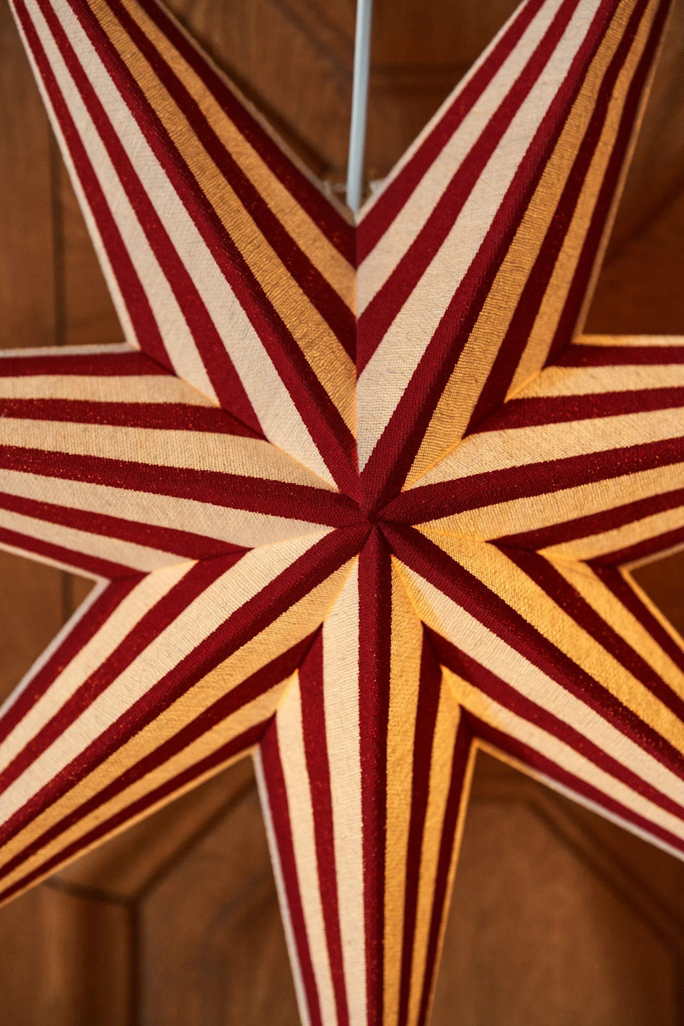 Close-up of an illuminated star-shaped decoration with red and white stripes.
