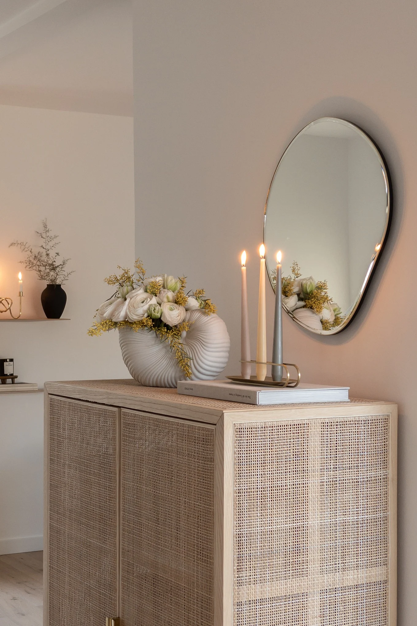 Create a Scandinavian home with @haus_tannenkamp, here you see a rattan cupboard with the Pond mirror and shell vase both from ferm living.