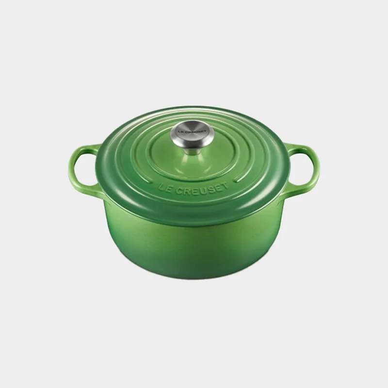 A bright green Le Creuset round Dutch oven with a matching lid and a silver knob, viewed from a slight angle.