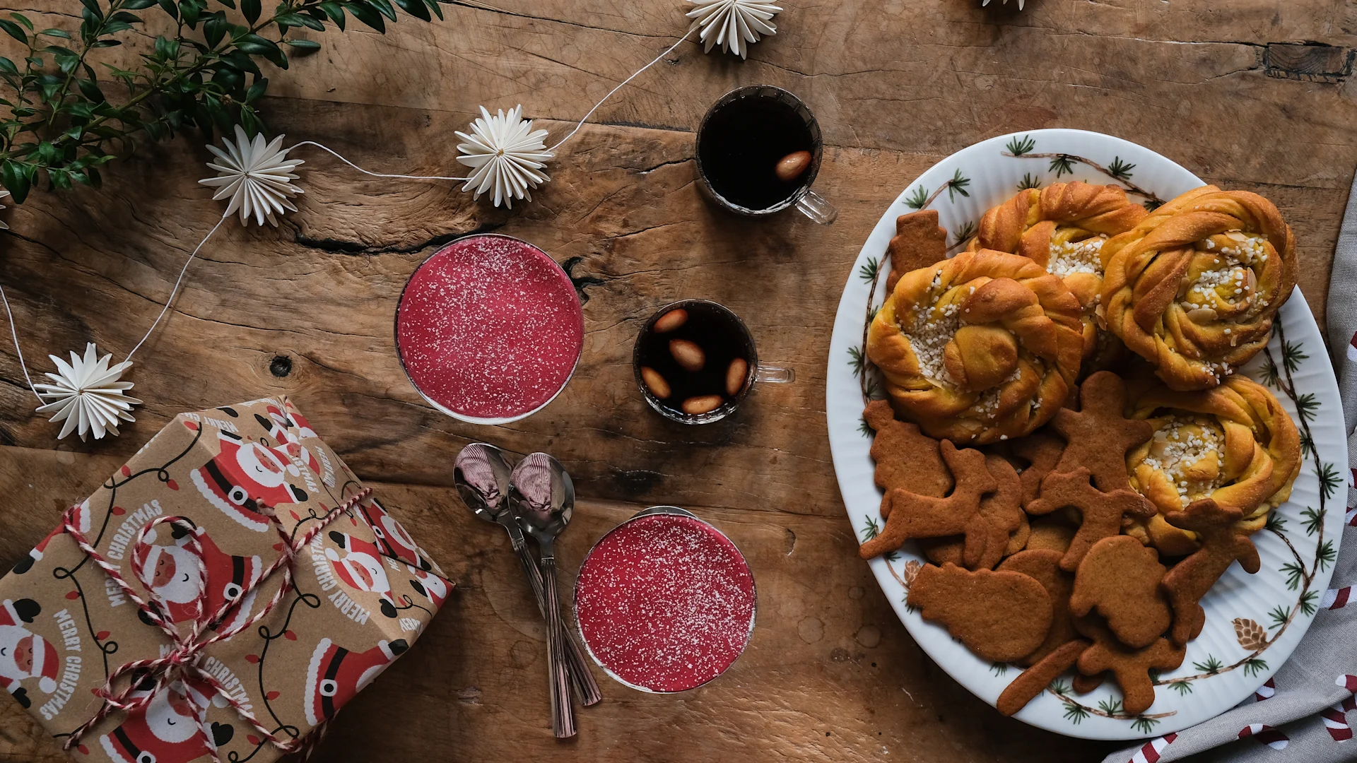 Swedish Christmas baking recipes: a large platter of saffron buns with vanilla and gingerbread cookies, as well as two dessert bowls with saffron princess cake.