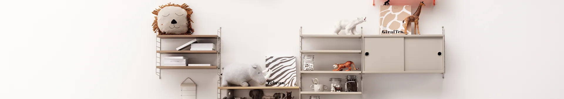 A children's room with a modular shelving system displaying animal-themed decor including plush lion and rhino, books, and various animal figurines.