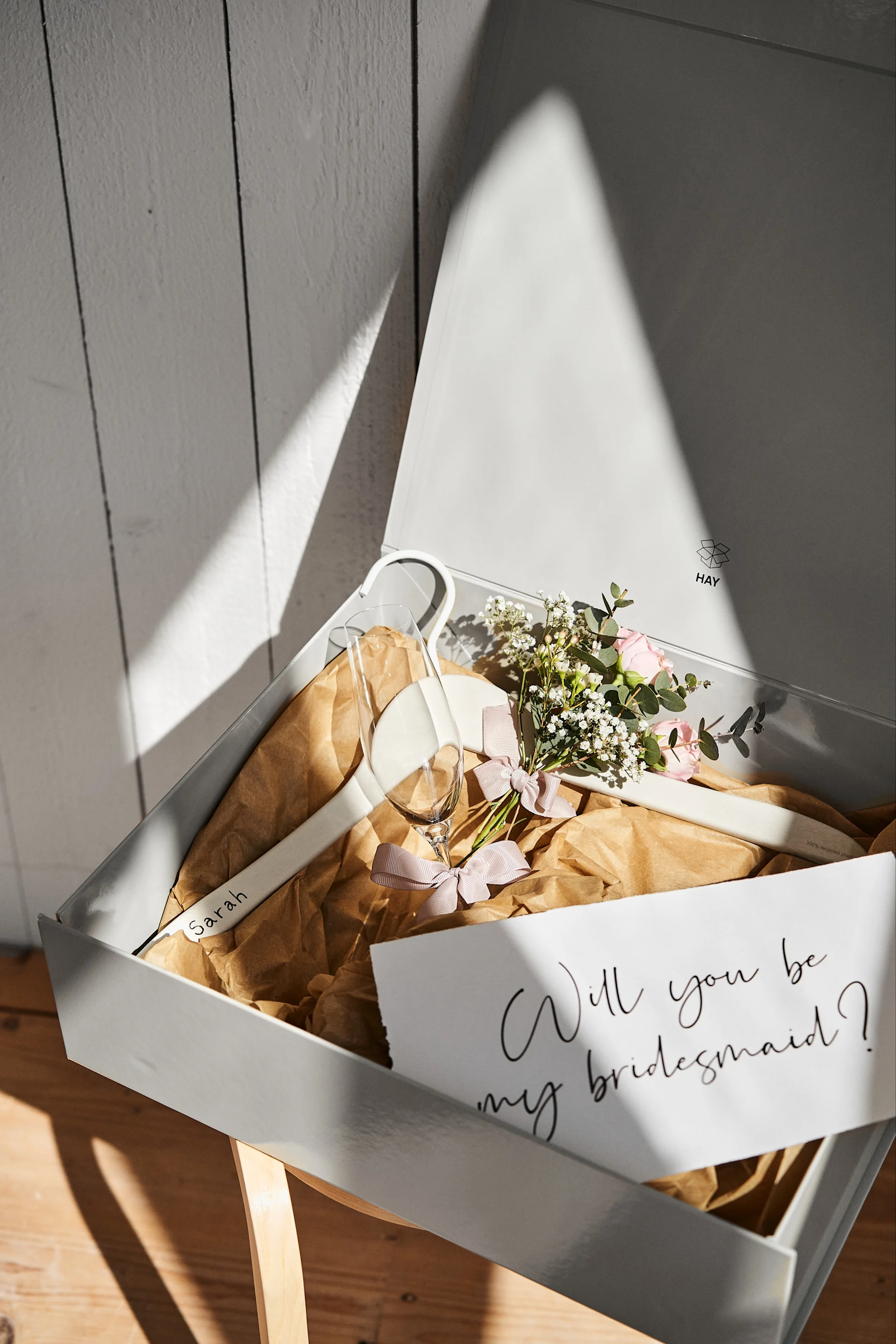 Be inspired by these unique wedding ideas like a personalised bridesmaid proposal in a grey storage box from HAY with a personalised hanger for the dress and a champagne glass to help you celebrate.