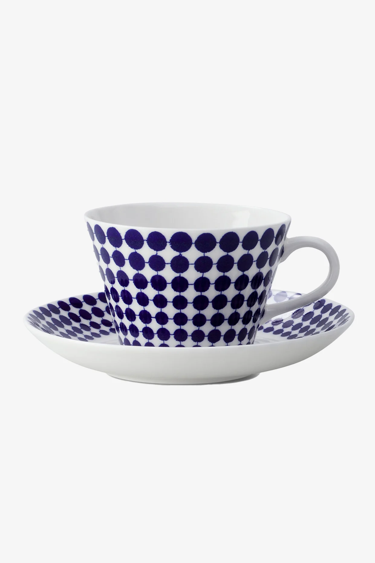 White teacup and saucer with a blue polka dot pattern.