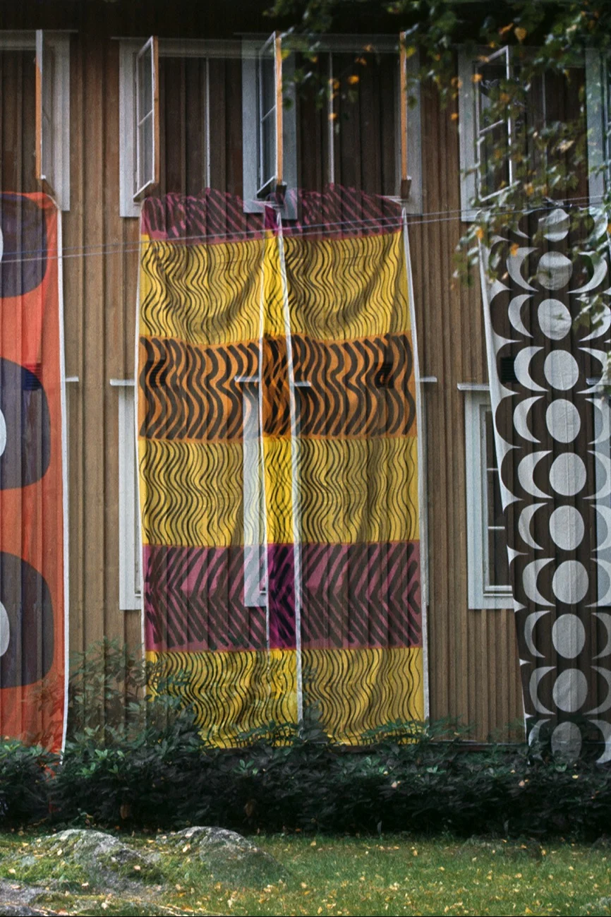 Streams of Marimekko fabric hang from the windows of an apartment block in Finland.