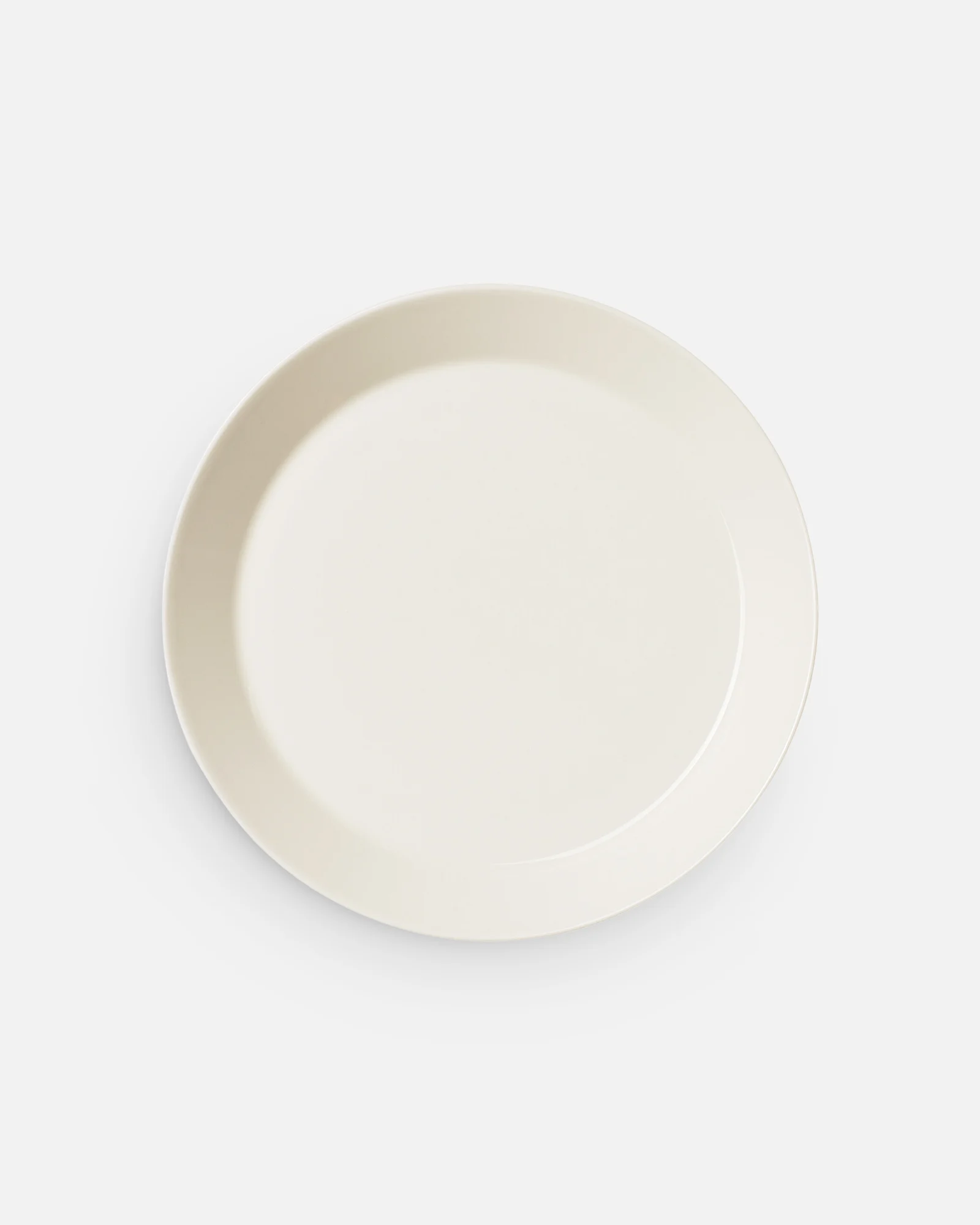 Overhead view of an empty, light cream oval plate on a white background.