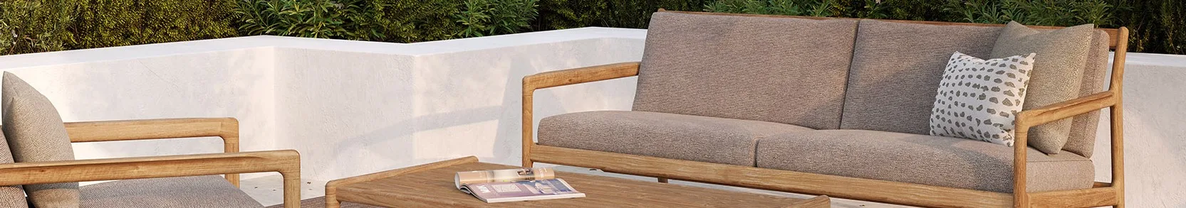 Outdoor patio with a wooden sofa and armchair, grey cushions, patterned pillow, and a coffee table with a magazine.
